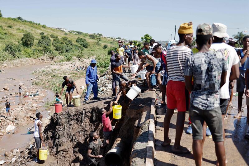 Residents try to collect clean water from a broken pipe on the side of a road in Amaoti, north of Durban. Victims of South Africa's worst flooding on record clamoured for relief as the death toll from the disaster that struck the coastal city of Durban surged past 300. AFP