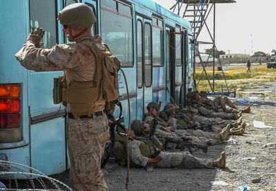 US soldiers rest as Afghans wait to leave the Kabul airport as the US withdraws from the country. AFP