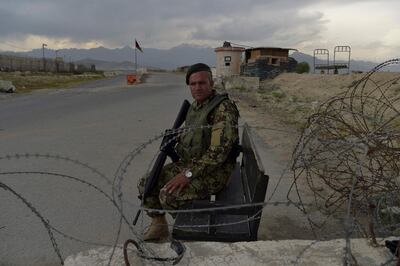 An Afghan National Army (ANA) soldier sits at a road checkpoint near the a US military base in Bagram, some 50 km north of Kabul on April 29, 2021. / AFP / WAKIL KOHSAR
