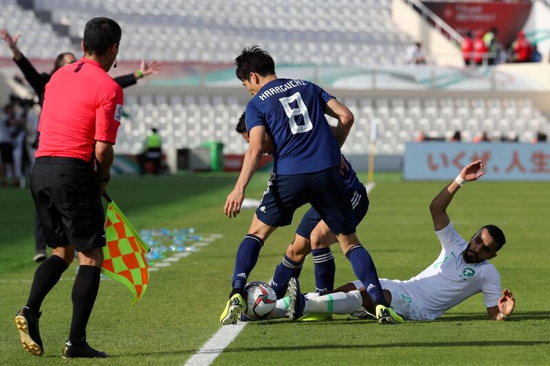 Saudi Arabia defender Mohammed Al-Burayk, right, falls after a challenge from Japan's midfielder Genki Haraguchi. AFP