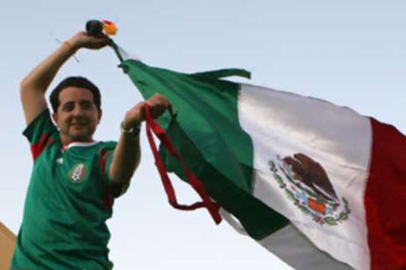 Pablo Mangino, a pilot with Etihad Airways, wears his Mexican football team uniform and waves his country's flag.