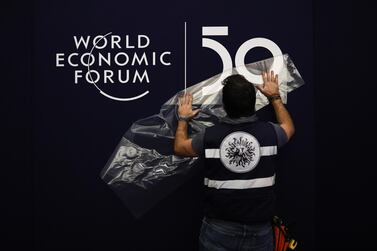 A worker applies a transfer on the wall inside the Congress Center ahead of the World Economic Forum (WEF) in Davos, Switzerland, on Monday, January 20, 2020. Bloomberg