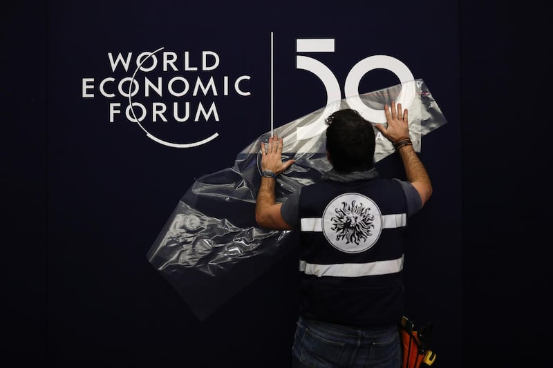A worker applies a transfer on the wall inside the Congress Center ahead of the World Economic Forum (WEF) in Davos, Switzerland, on Monday, Jan. 20, 2020. World leaders, influential executives, bankers and policy makers attend the 50th annual meeting of the World Economic Forum in Davos from Jan. 21 - 24. Photographer: Simon Dawson/Bloomberg