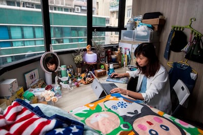 This picture taken on April 28, 2018 shows Jezz Ng siting at her desk where she rents a small living space in a co-sharing building in the Mong Kok district of Hong Kong. As housing prices spiral in Hong Kong, young professionals are living in ever-shrinking spaces, with box-like "nano-flats" and co-shares touted as fashionable solutions. - TO GO WITH AFP STORY: Hong Kong-housing-social-lifestyle-urban-planning, FEATURE Yan ZHAO

 / AFP / ISAAC LAWRENCE / TO GO WITH AFP STORY: Hong Kong-housing-social-lifestyle-urban-planning, FEATURE Yan ZHAO

