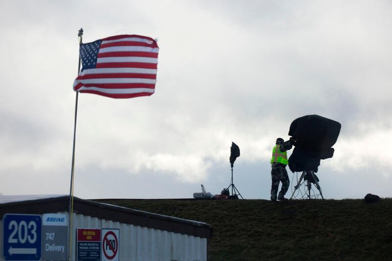 A camera operator covers his equipment after the first flight event for the Boeing 777X airplane had to be rescheduled due to weather at Paine Field in Everett, Washington on January 24, 2020. AFP