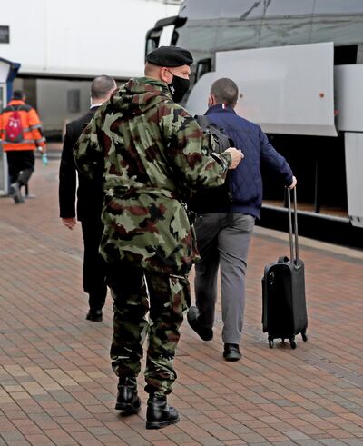 DUBLIN, IRELAND - MARCH 29: A passenger is escorted to a bus to be taken to the Crowne Plaza hotel for quarantine on March 29, 2021 in Dublin, Ireland. Last week, Ireland started requiring travelers from 33 high-risk countries to be shuttled to a mandatory 12-day hotel quarantine. Over the weekend, three quarantined travelers absconded from their hotel, forcing authorities to track them down. (Photo by Donall Farmer/Getty Images)