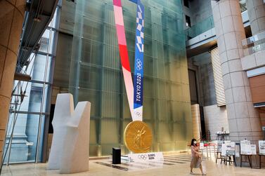 A woman wearing a protective mask, following the coronavirus disease (COVID-19) outbreak, walks past a large-scale reproduction of Tokyo 2020 Olympic Games medal at Nihonbashi Mitsui Tower in Tokyo, Japan, July 14, 2021.    REUTERS / Kim Kyung-Hoon