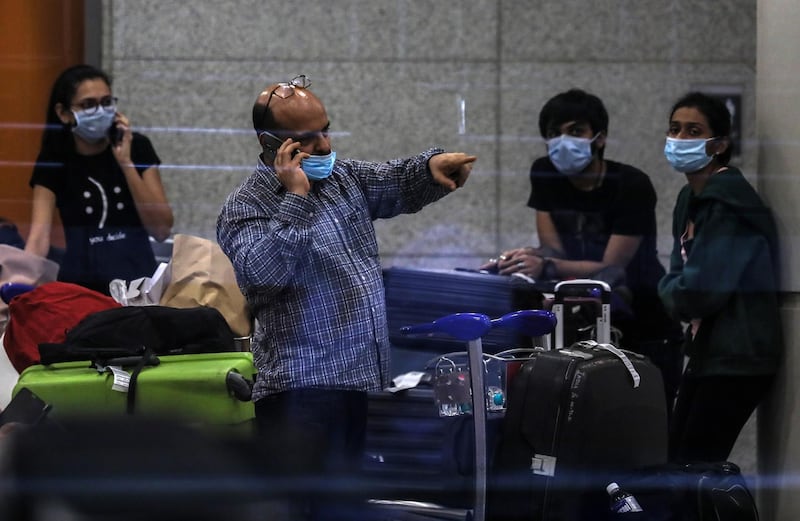 Stranded Indian passengers who arrived by an Air India flight from Singapore wait to come out of the terminal. EPA