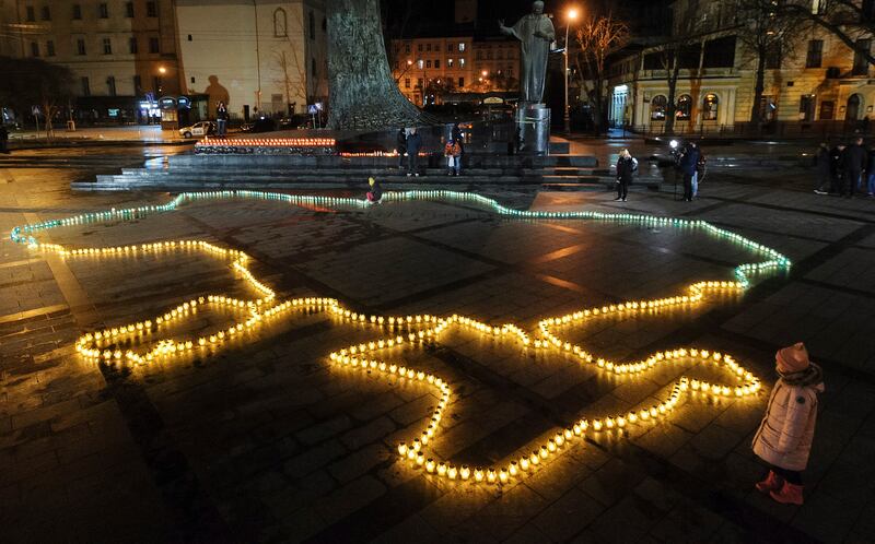 Ukrainians light candles to form a map of the country on the central square of the city of Lviv, in memory of innocent civilians killed since the Russian invasion.  EPA