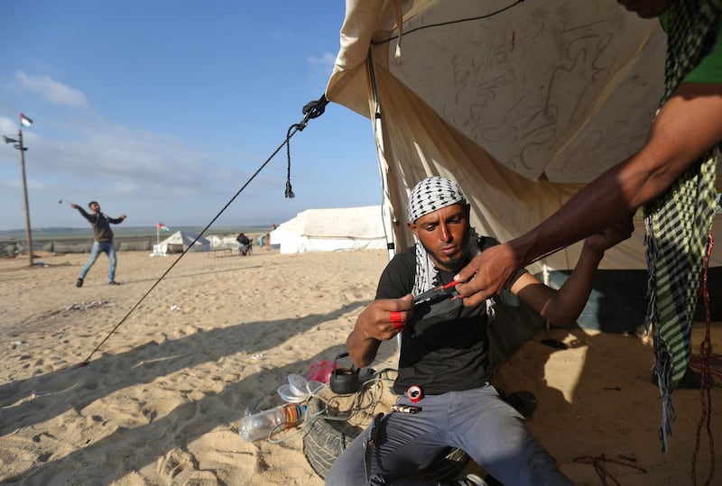 A man prepares a slingshot as Palestinians prepare to demonstrate along the border with the Gaza strip, east of Jabalia. Mohammed Abed / AFP
