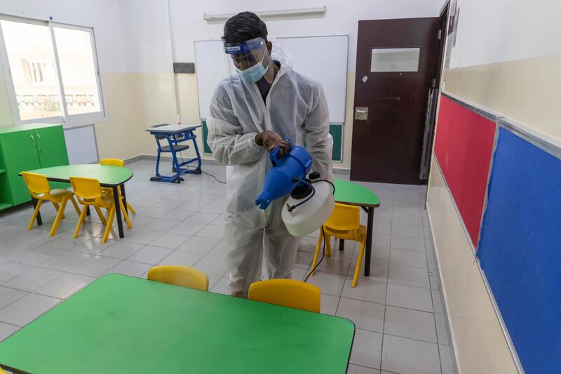 A cleaner sanitises the furniture.