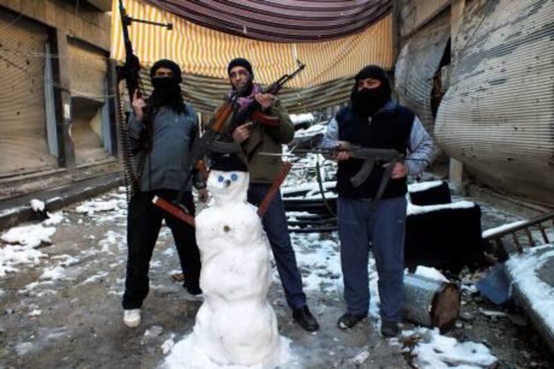 Members of the Free Syrian Army pose with their weapons and a snowman at the Jouret al Shayah area in Homs January 10, 2013. Picture taken January 10, 2013.                            REUTERS/Yazan Homsy (SYRIAS - Tags: CONFLICT MILITARY TPX IMAGES OF THE DAY) *** Local Caption ***  SYR15_SYRIA-CRISIS-_0111_11.JPG