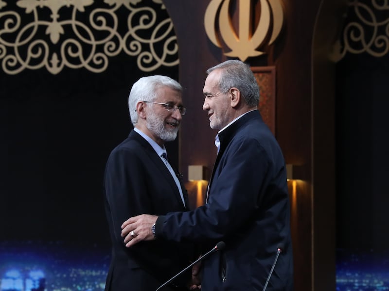 Ultraconservative former nuclear negotiator Saeed Jalili (left) and reformist candidate Masoud Pezeshkian greet each other before a TV debate ahead of the second round of the presidential election, in Tehran, Iran, on July 1. EPA