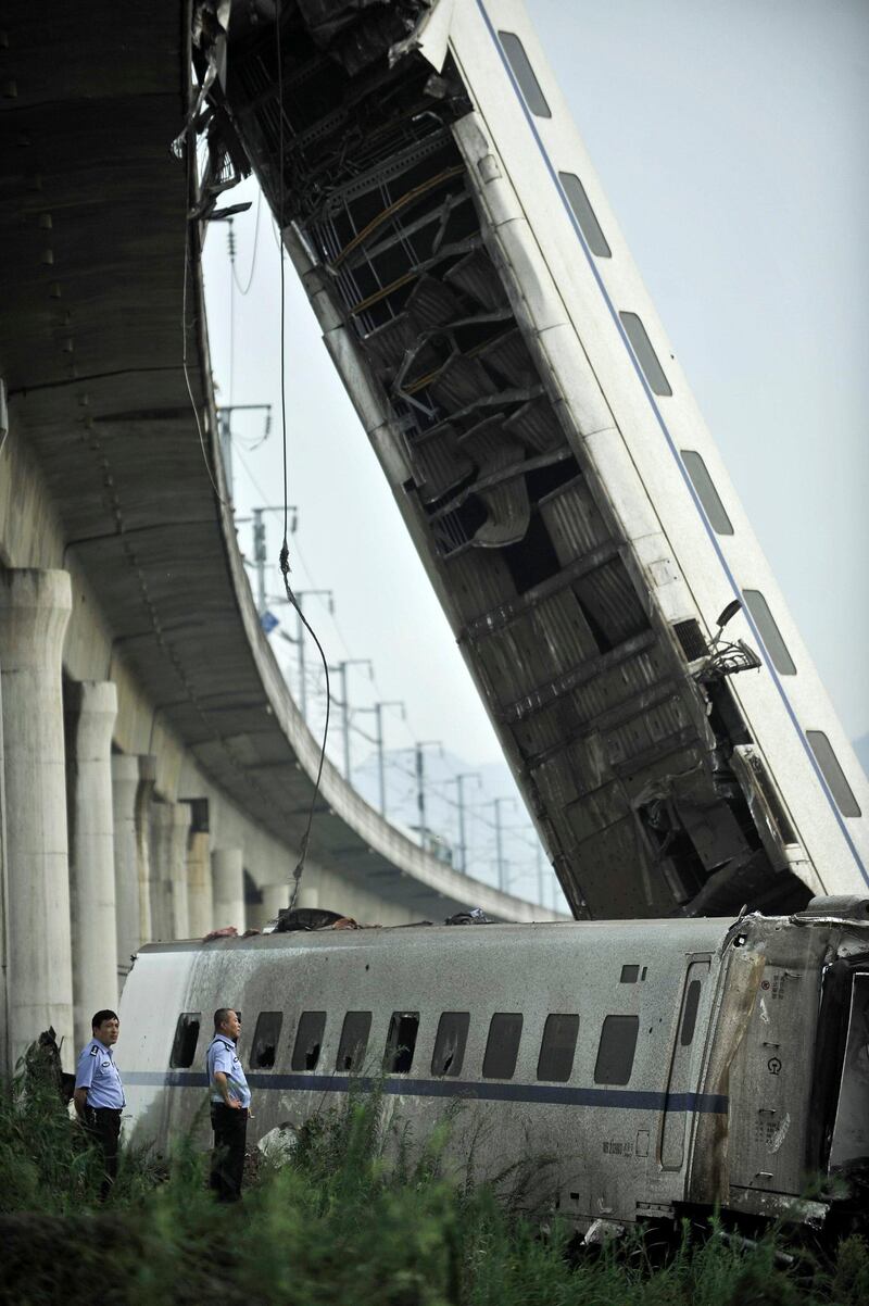 Chinese police officers look at the wreckage of a train accident in Wenzhou in east China's Zhejiang province, Sunday, July 24, 2011. A Chinese bullet train crashed into another high-speed train that had stalled after being struck by lightning Saturday in eastern China, causing four carriages to fall off a viaduct. (AP Photo) CHINA OUT *** Local Caption ***  APTOPIX China Train Crash.JPEG-0470c.jpg