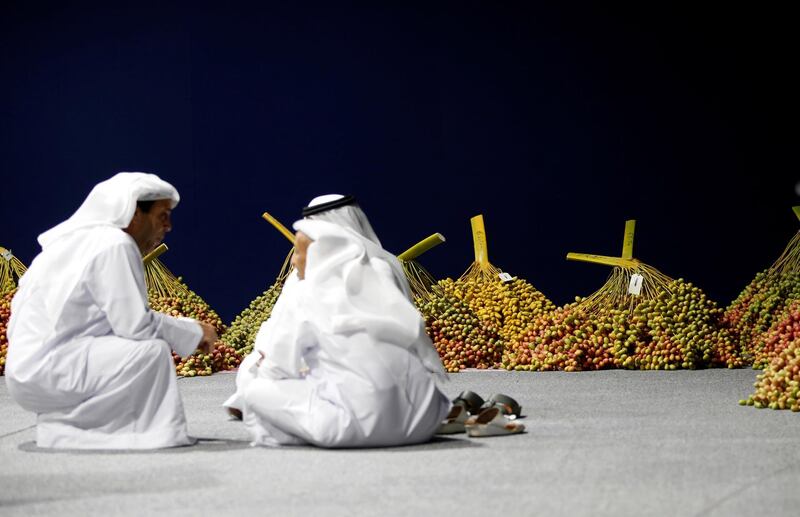 Judges discuss about heaviest Etheg (branch of dates) at Al Dabbas competition. EPA