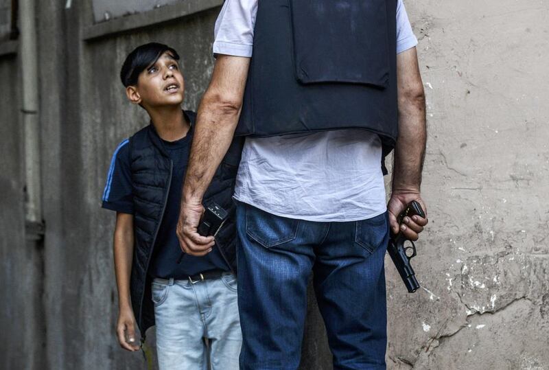 Elsewhere, a Turkish policeman asks a young Kurdish boy questions following an attack against police officers in the mainly Kurdish city of Diyarbakir on July 23, 2015. Ilyas Akengin/AFP Photo

