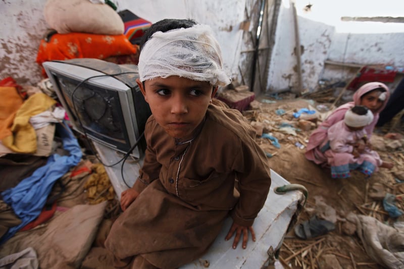 An injured boy sits in a damaged house in Peshawar, Pakistan, after a7.6 magnitude earthquake struck in October 2015, killing 86,000