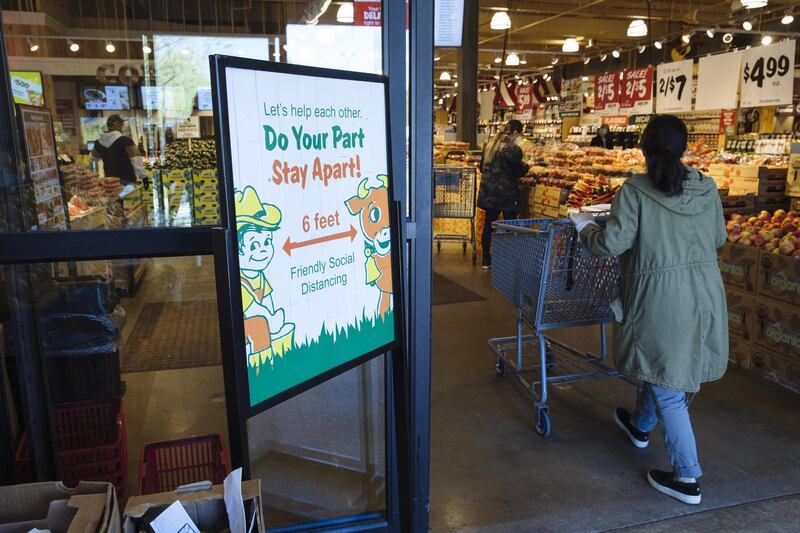 A social distancing sign is displayed at the entrance to a supermarket in Paramus, New Jersey, US. Bloomberg