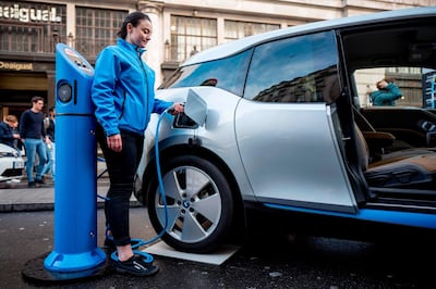 A BMW staff member poses for a photograph as she connects a BMW i3 electric vehicle (EV) to a charging point during Regent Street Motor Show on November 4, 2017 in London. 
A driverless, electric car is only a swipe away in the cities of the future, where pollution clampdowns and rapid advances in technology will transform the way we travel, despite lagging infrastructure. A switch from petrol to electric vehicles (EVs) is under way. Britain and France intend to ban the sale of fully petrol or diesel cars from 2040, while smog-plagued India wants to sell only electric cars by 2030.  Expert motoring journalist Matt Robinson said a "woeful lack" of suitable charging points remained a big problem for electric car users. / AFP PHOTO / TOLGA AKMEN