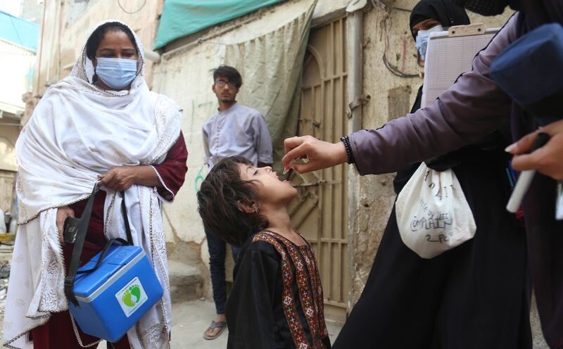 A health worker administers polio vaccine to children in Karachi, Pakistan. Childhood vaccination rates have declined. EPA
