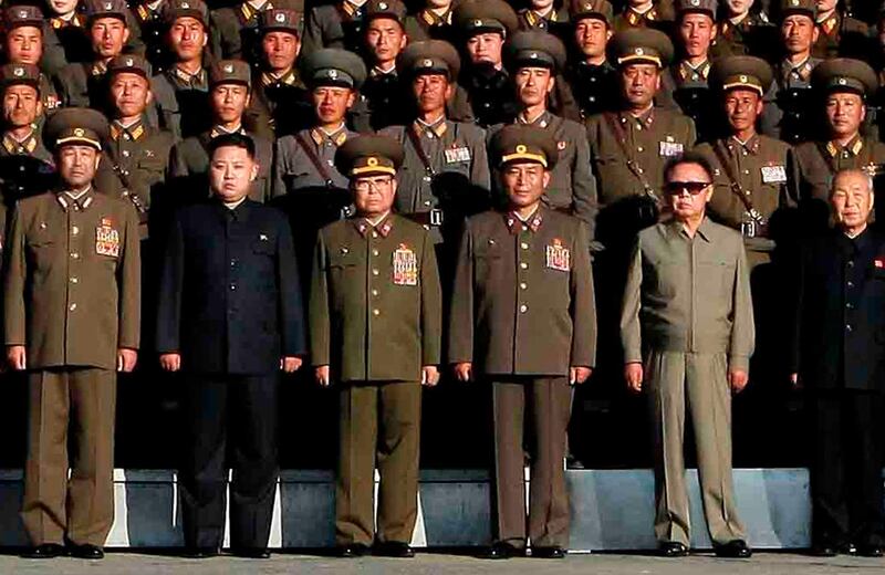 North Korean leader Kim Jong-il (front 2nd R) wearing sunglasses, his son Kim Jong-un in black suit (front 2nd L) and other officials pose with soldiers at a military unit in an undisclosed location in North Korea in this undated picture released by the North's KCNA news agency in Pyongyang October 6, 2010. North Korean leader Kim Jong-il died on a train trip, state television reported on December 19, 2011 sparking immediate concern over who is in control of the reclusive state and its nuclear programme. A tearful announcer dressed in black said the 69-year old had died on December 17, 2011 of physical and mental over-work on his way to give "field guidance".     REUTERS/KCNA/Files (NORTH KOREA - Tags: MILITARY POLITICS TPX IMAGES OF THE DAY OBITUARY) NO THIRD PARTY SALES. NOT FOR USE BY REUTERS THIRD PARTY DISTRIBUTORS *** Local Caption ***  PYO02_KOREA-NORTH-_1219_11.JPG