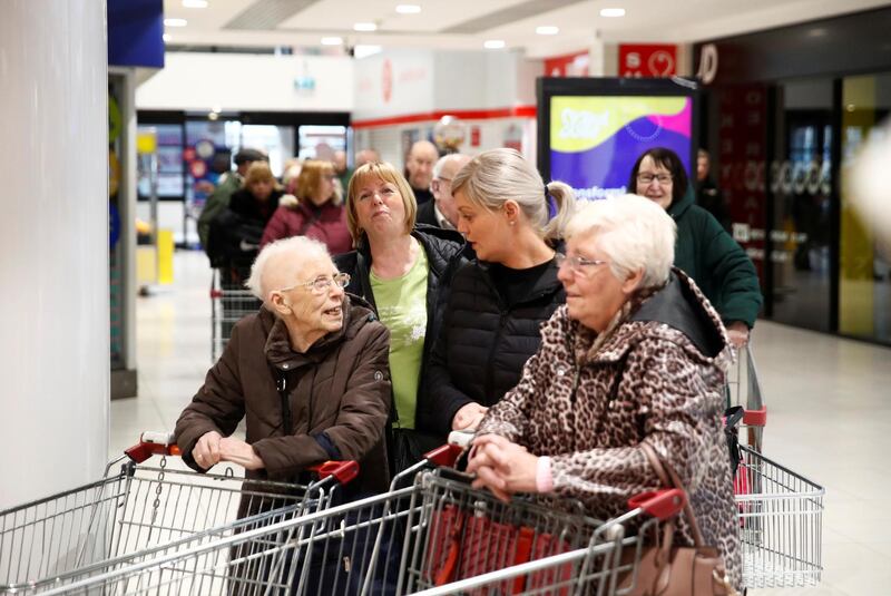 People wait outside an Iceland store in the Kennedy Centre which opened one hour early to allow elderly shoppers to buy food, in Belfast, Northern Ireland, Britain, March 17, 2020. Reuters