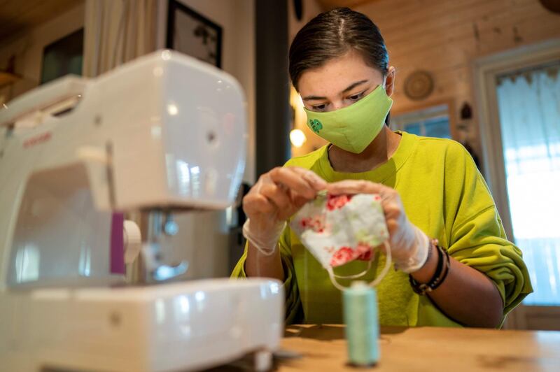 A teenager sews colourful face masks for friends and family on April 20, 2020 in Nesodden, Norway. AFP