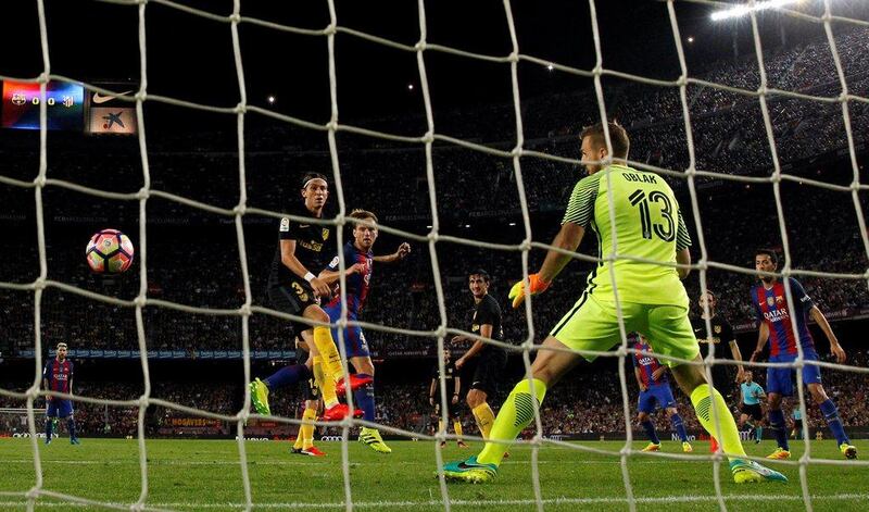 Barcelona’s Ivan Rakitic heads the ball to score a goal against Atletico Madrid’s Filipe Luis and goalkeeper Jan Oblak. Albert Gea / Reuters
