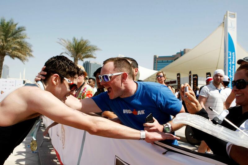 Abu Dhabi, United Arab Emirates, March 2, 2013:    An age group athelete celebrates with spectator after crossing the finish line during the Abu Dhabi International Triathlon in Abu Dhabi on March 2, 2013. Christopher Pike / The National