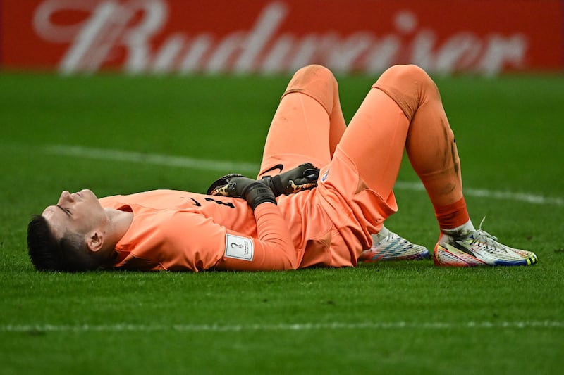 Croatia's goalkeeper Dominik Livakovic lies on the ground after fouling Argentina's Julian Alvarez to concede a penalty. AFP