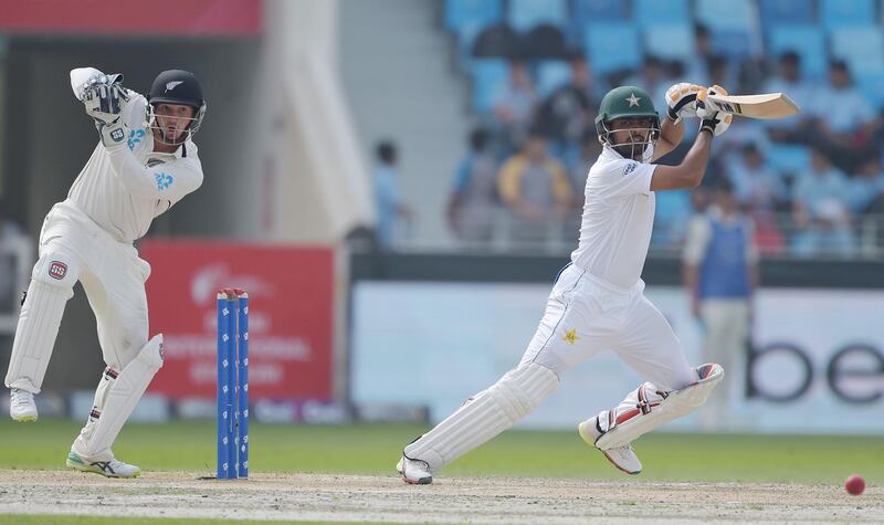 Pakistani batsman Babar Azam (R) plays a shot as New Zealand wicketkeeper BJ Watling looks on during the second day of the second Test cricket match between Pakistan and New Zealand at the Dubai International Stadium in Dubai on November 25, 2018. / AFP / AAMIR QURESHI
