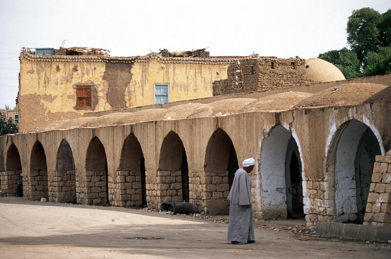 APNRX1 An old Arab walking towards the arches of a building in New Gurna built in the late 1940 s to accommodate villagers from Old Gurna and designed by Hassan Fathy architect for the poor. Alamy