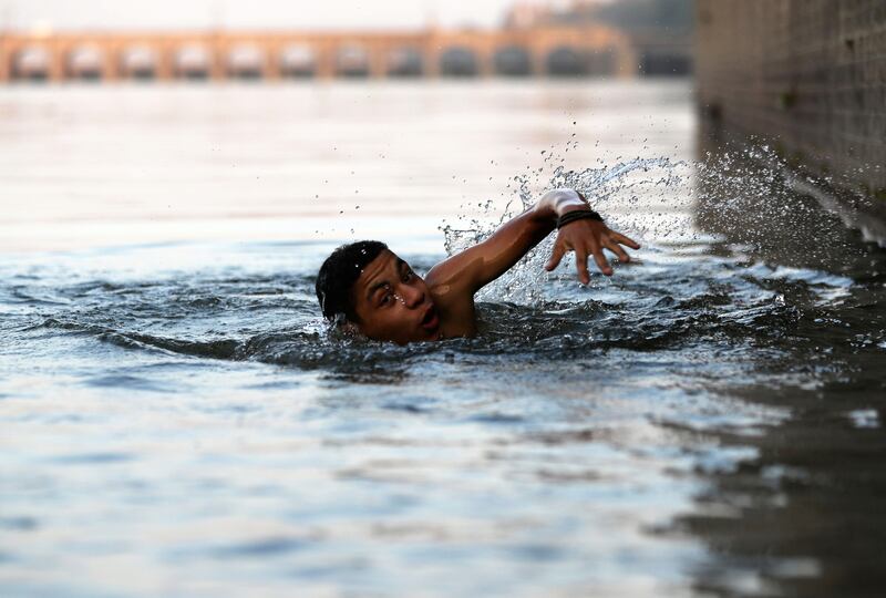 A boy swims in the Nile during hot weather in Al Qanater, about 10 kilometres north-west of Cairo, Egypt.