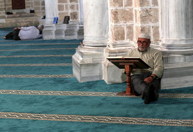 A Palestinian elder reads from the Quran before at Al Omari mosque in Gaza City.  EPA