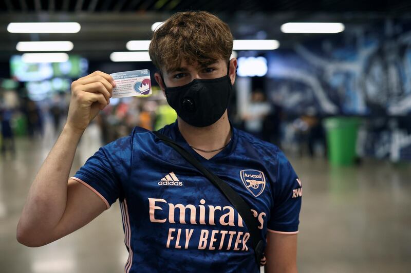 An Arsenal football club fan shows his vaccination card after receiving a dose of the Pfizer BioNTech COVID-19 vaccine at a mass vaccination centre for those aged 18 and over at the Tottenham Hotspur Stadium, amid the coronavirus disease (COVID-19) pandemic, in London, Britain, June 20, 2021. REUTERS/Henry Nicholls