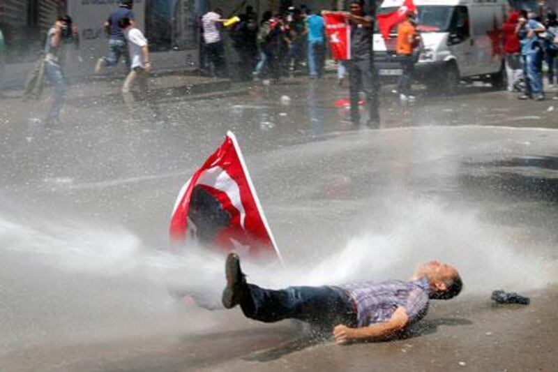 A man is hit by water cannon during protests in Ankara on Saturday. Umit Bektas / Reuters