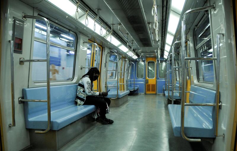A woman wearing a protective face mask sits inside an empty metro train, as she travels on a line Shubra Al Khaimah to Tahrir Square, before the start of a night-time curfew amid concerns over the spread of the coronavirus disease, on the outskirts of Cairo. Reuters