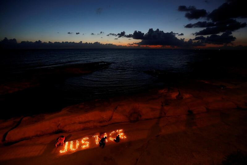 Activists from anti-corruption group Occupy Justice light candles spelling out the word 'Justice' to mark ten months since the assassination of investigative journalist Daphne Caruana Galizia, on a beach in Sliema, Malta. Reuters