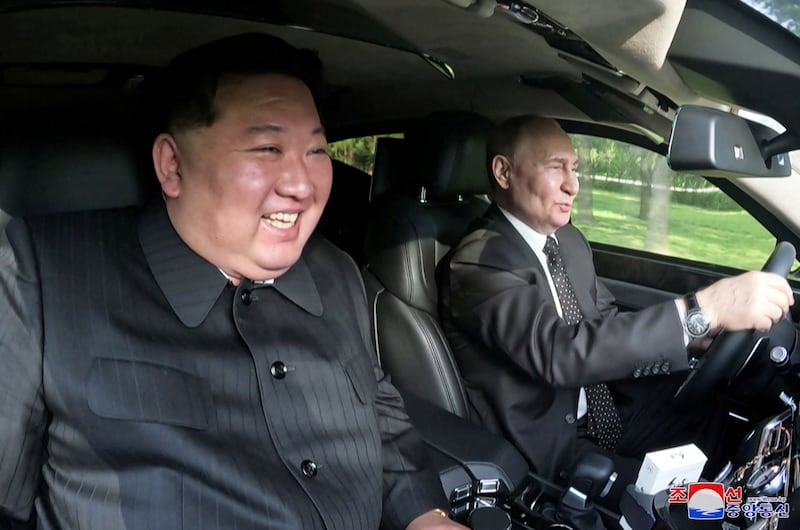 Mr Putin and Mr Kim ride in a car in Pyongyang. Reuters
