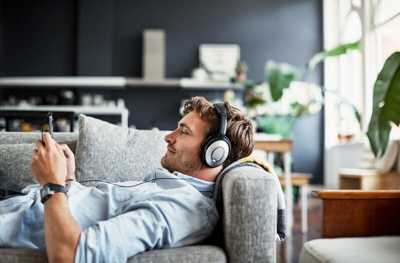 Cropped shot of a handsome young man listening to music on his mobile phone at home