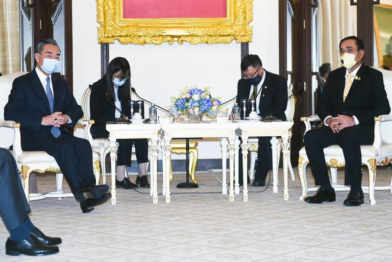 Chinese Foreign Minister Wang Yi, left, meets  Thai Prime Minister Prayuth Chan-ocha at the Government House in Bangkok during a two-day visit to promote a socio-economic recovery plan amid the Covid-19 pandemic.  EPA