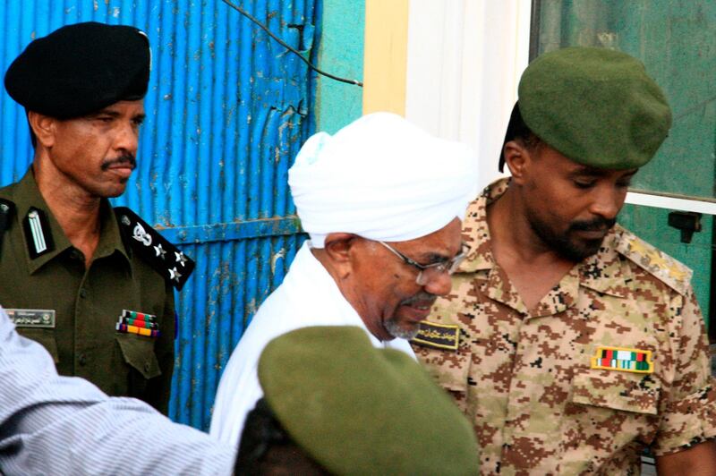 Fallen Sudanese leader Omar al-Bashir is escorted before being driven in an armed convoy from the Kober prison to the prosecutor's office in North Khartoum on June 16, 2019. Bashir was On June 16 seen in public for the first time since being ousted, as he was driven to the prosecutor's office. The former strongman, who ruled his northeast African nation with an iron fist for three decades, was toppled on April 11 after weeks of protests against his reign. / AFP / Ebrahim Hamid
