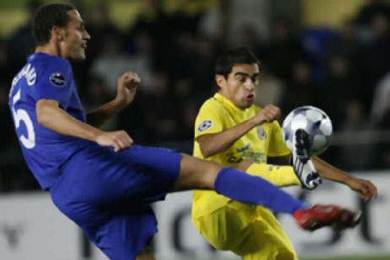 The Manchester United defender Rio Ferdinand, left, kicks the ball past Ariel Ibagaza of Villarreal.