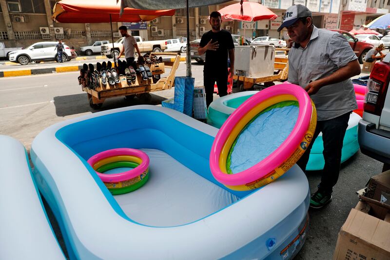 A shopkeeper puts out children's inflatable tubs for sale on a street in Baghdad.