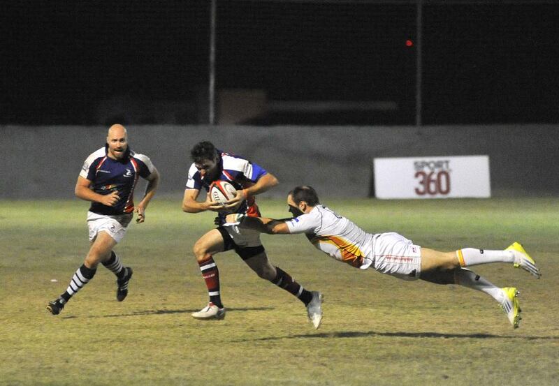 Andy Russel, centre, of the Jebel Ali Dragons breaks tackles from Dubai Hurricanes. The Dragons defeated the Hurricanes 37-8 for the UAE Premiership on November 8 in Dubai. Charles Crowell / for The National