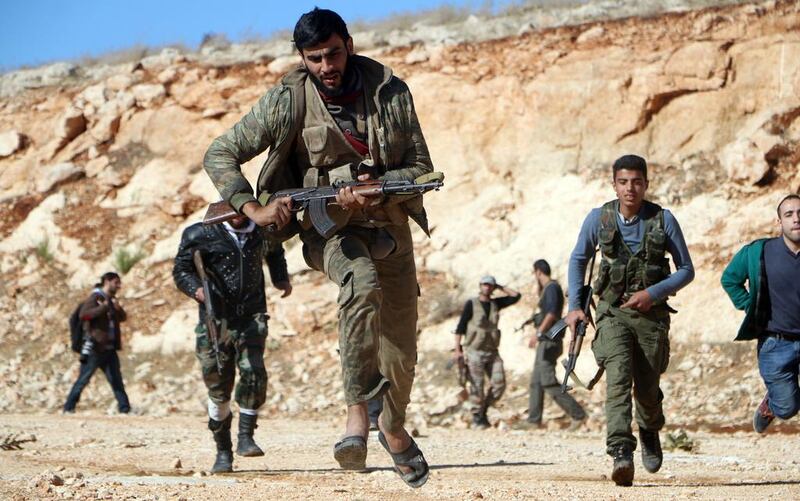 Rebel fighters run during a battle against Syrian government soldiers in Handarat, on the northern outskirts of Aleppo. Fadi Al Halabi / AFP