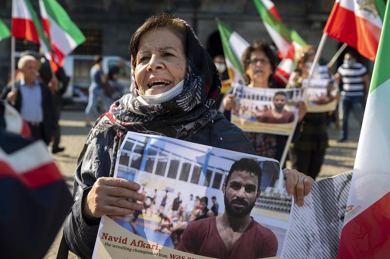 A woman holds a portrait of Iranian wrestler Navid Afkari during a demonstration on the Dam Square in Amsterdam, the Netherlands, on September 13, 2020, against its execution in the southern Iranian city of Shiraz and against the Iranian government. Iran said it executed wrestler Navid Afkari, 27, on September 12, 2020 at a prison in the southern city of Shiraz over the murder of a public sector worker during anti-government protests in August 2018. Reports published abroad say Afkari was condemned on the basis of confessions extracted under torture, prompting online campaigns of support for his release. - Netherlands OUT
 / AFP / ANP / Evert Elzinga
