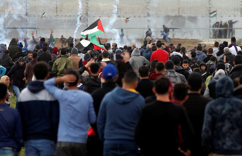 Palestinians gather as tear gas is fired by Israeli forces during a protest. Reuters