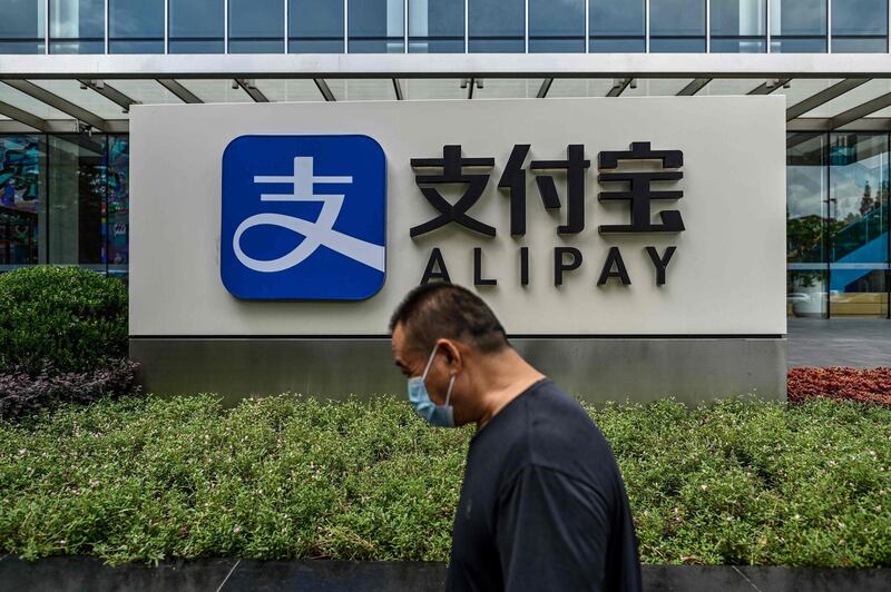 (FILES) This file photo taken on August 28, 2020 shows a pedestrian walking past an Alipay logo at the Shanghai office building of Ant Group in Shanghai.  US President Donald Trump on January 5, 2021 ordered a ban on Alipay, WeChat Pay and other apps linked to Chinese companies, saying they could route user information to the government in Beijing. / AFP / HECTOR RETAMAL
