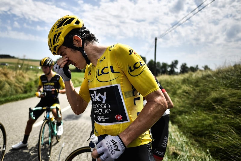 TOPSHOT - Great Britain's Geraint Thomas cleans his eyes after tear gas was used during a farmers' protest who attempted to block the stage's route, during the 16th stage of the 105th edition of the Tour de France cycling race, between Carcassonne and Bagneres-de-Luchon, southwestern France, on July 24, 2018.  The race was halted for several minutes on July 24 after tear gas was used as protesting farmers attempted to block the route. / AFP / Marco BERTORELLO
